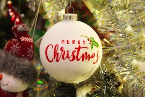 traditional silver, round Christmas ornament with the words Merry Christmas on it in red