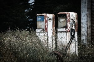 rusted fuel pumps with long grass